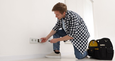 Photo of Man with tools installing new socket at home