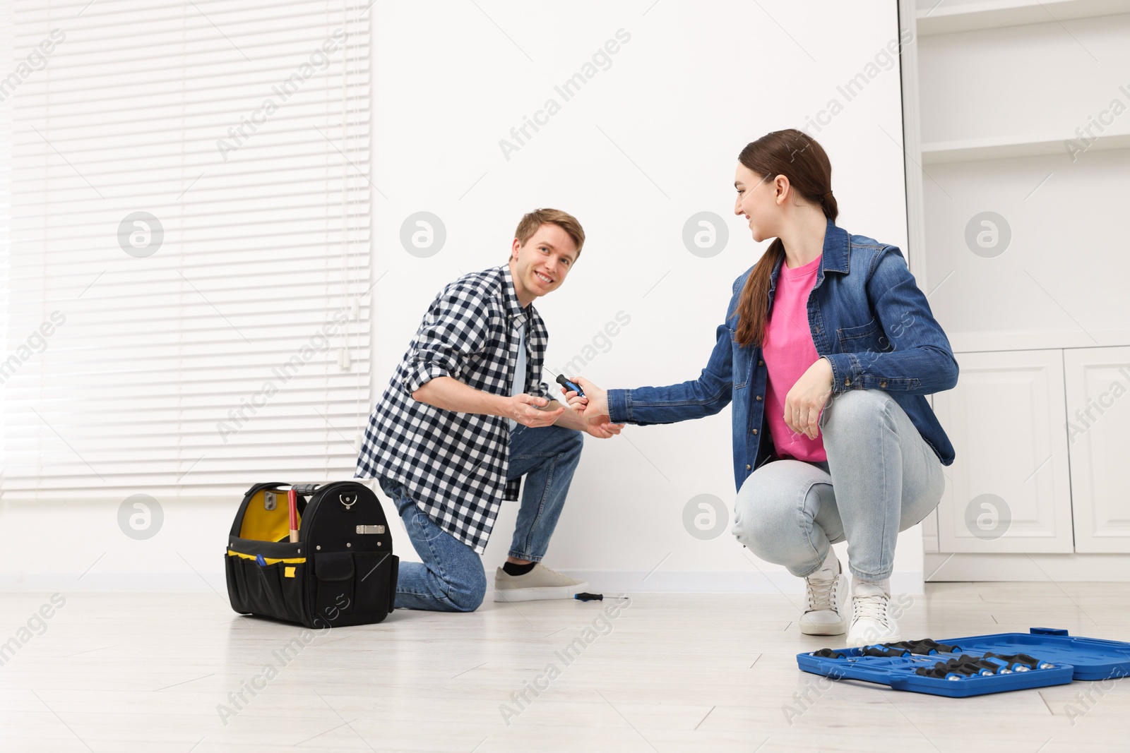 Photo of Couple with tools installing new socket at home