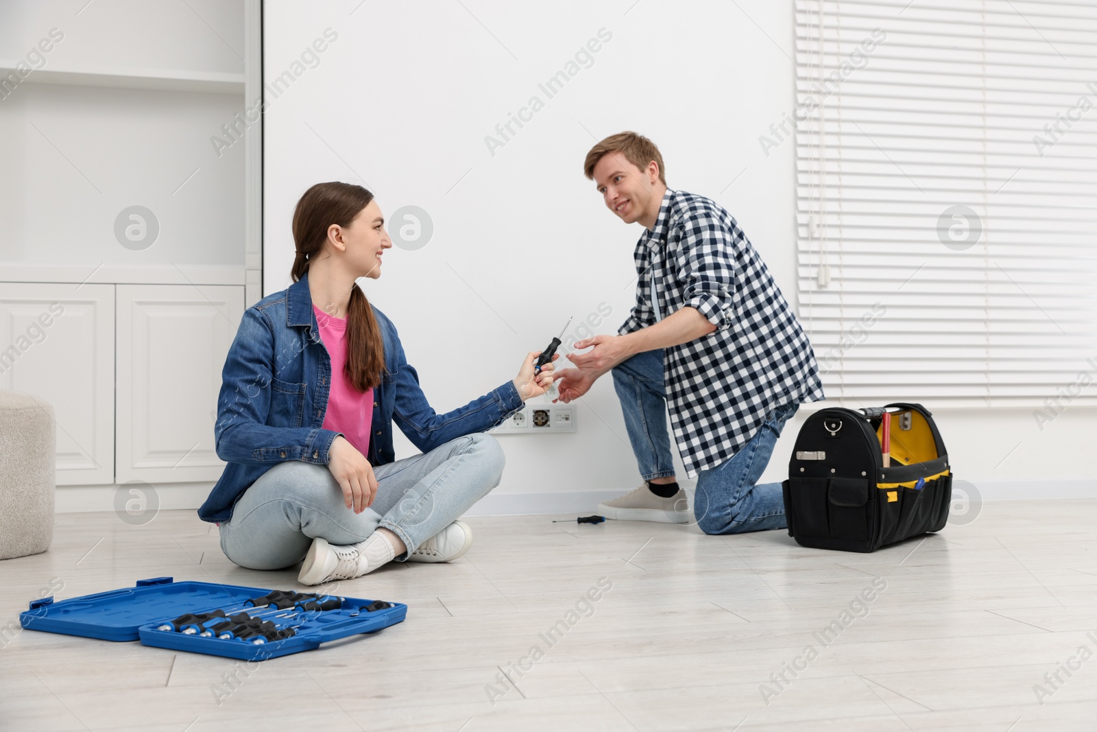 Photo of Couple with tools installing new socket at home
