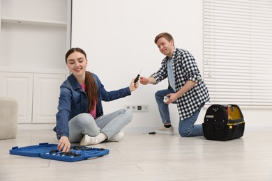 Photo of Couple with tools installing new socket at home