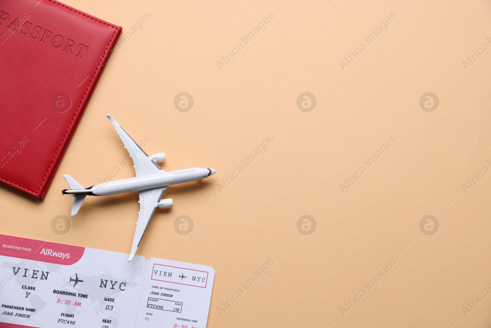 Photo of Airplane model, passport and flight ticket on beige background, flat lay. Space for text