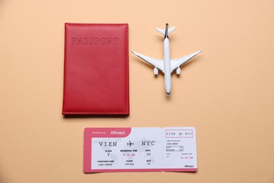 Photo of Airplane model, passport and flight ticket on beige background, flat lay
