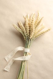 Photo of Bunch of wheat spikes on paper background, top view