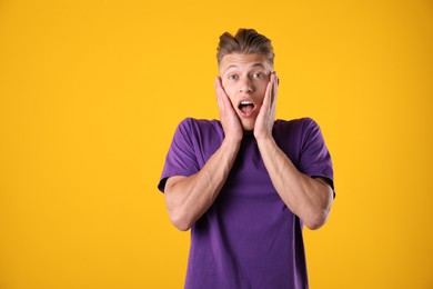 Photo of Portrait of surprised man on orange background, space for text