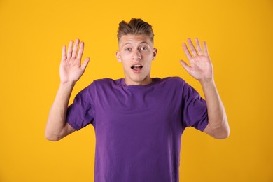Photo of Portrait of surprised man on orange background