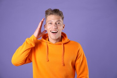 Photo of Portrait of surprised man on purple background