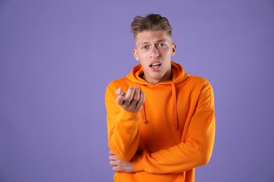 Photo of Portrait of surprised man on purple background, space for text