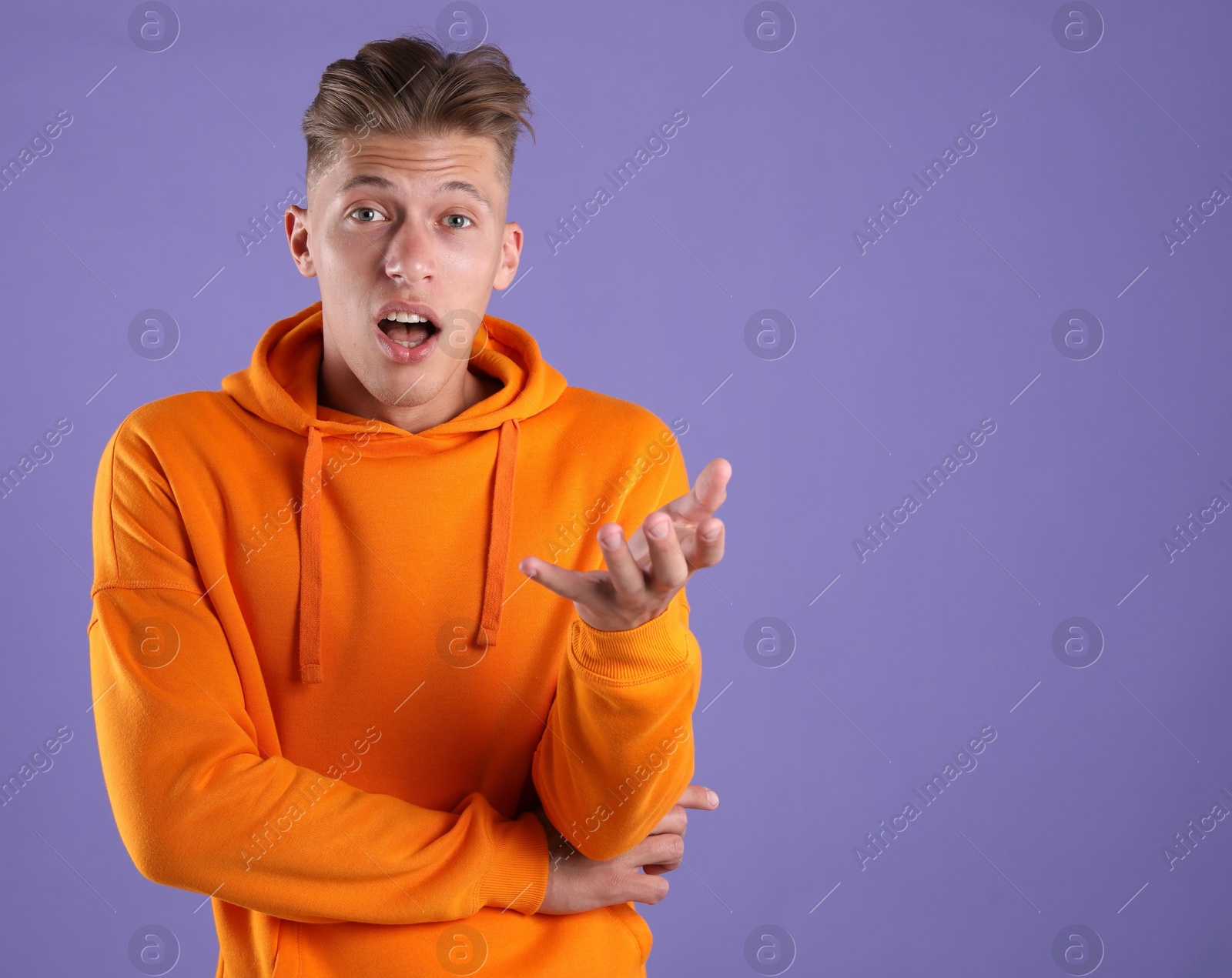 Portrait of surprised man on purple background, space for text Photo of Portrait of surprised man on purple background, space for text