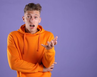 Photo of Portrait of surprised man on purple background, space for text