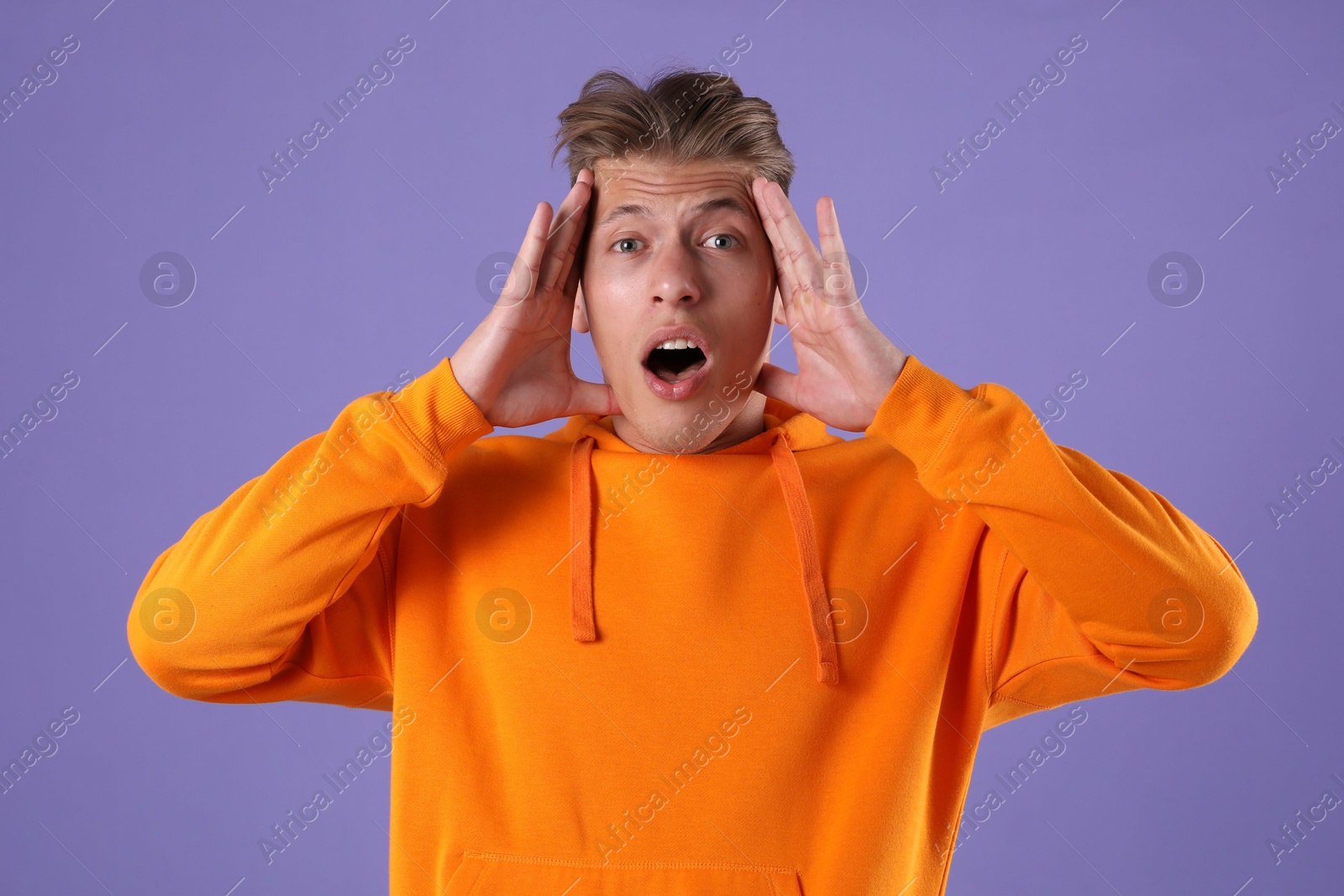 Portrait of surprised man on purple background Photo of Portrait of surprised man on purple background