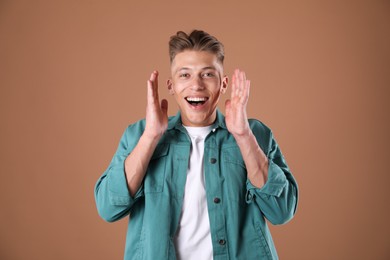 Photo of Portrait of surprised man on brown background