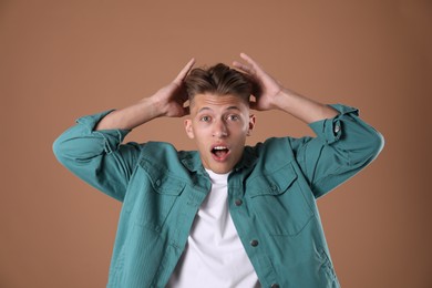 Photo of Portrait of surprised man on brown background