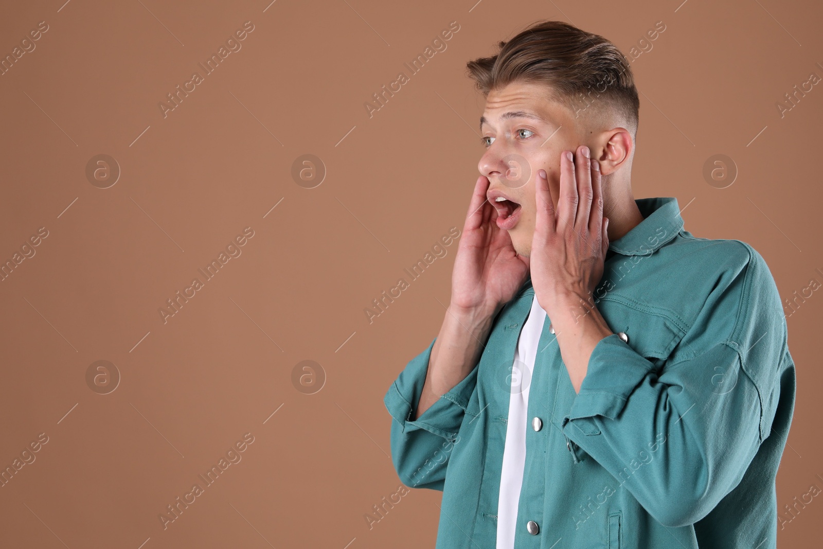 Portrait of surprised man on brown background, space for text Photo of Portrait of surprised man on brown background, space for text