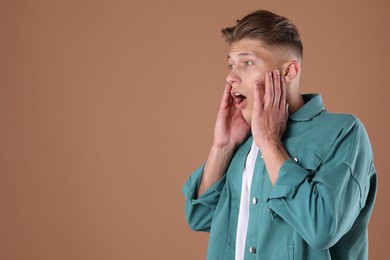 Photo of Portrait of surprised man on brown background, space for text