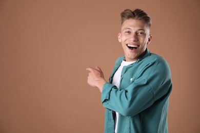 Photo of Portrait of surprised man on brown background, space for text