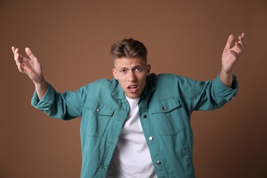 Photo of Portrait of shocked man on brown background