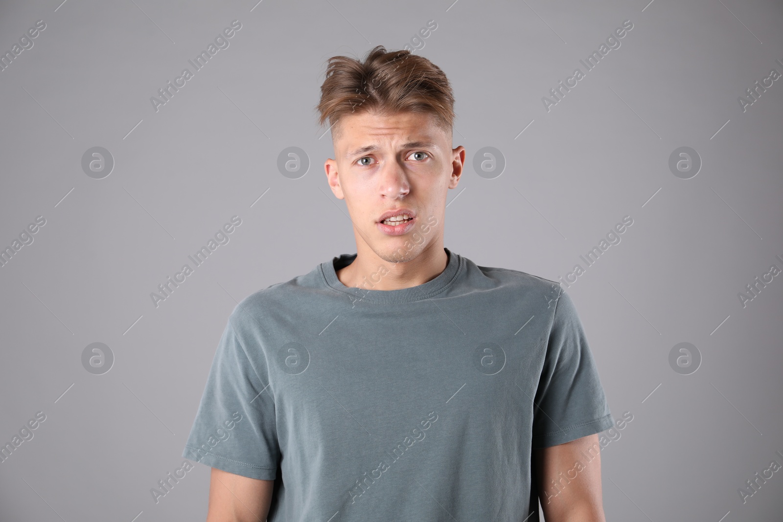 Photo of Portrait of confused man on grey background