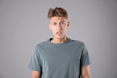 Photo of Portrait of confused man on grey background