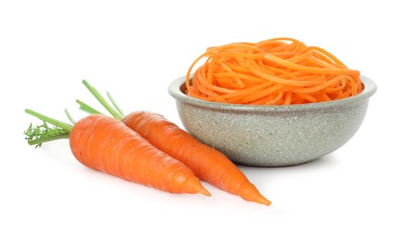 Photo of Raw carrot noodles and fresh vegetables isolated on white. Vegetarian dish