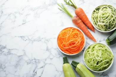 Photo of Different vegetarian noodles and fresh vegetables on white marble table, flat lay. Space for text
