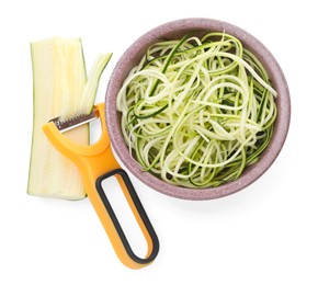 Photo of Raw zucchini noodles in bowl , peeler and fresh vegetable isolated on white, top view. Vegetarian dish