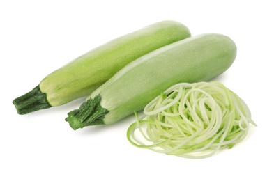 Photo of Raw squash noodles and fresh vegetables isolated on white. Vegetarian dish