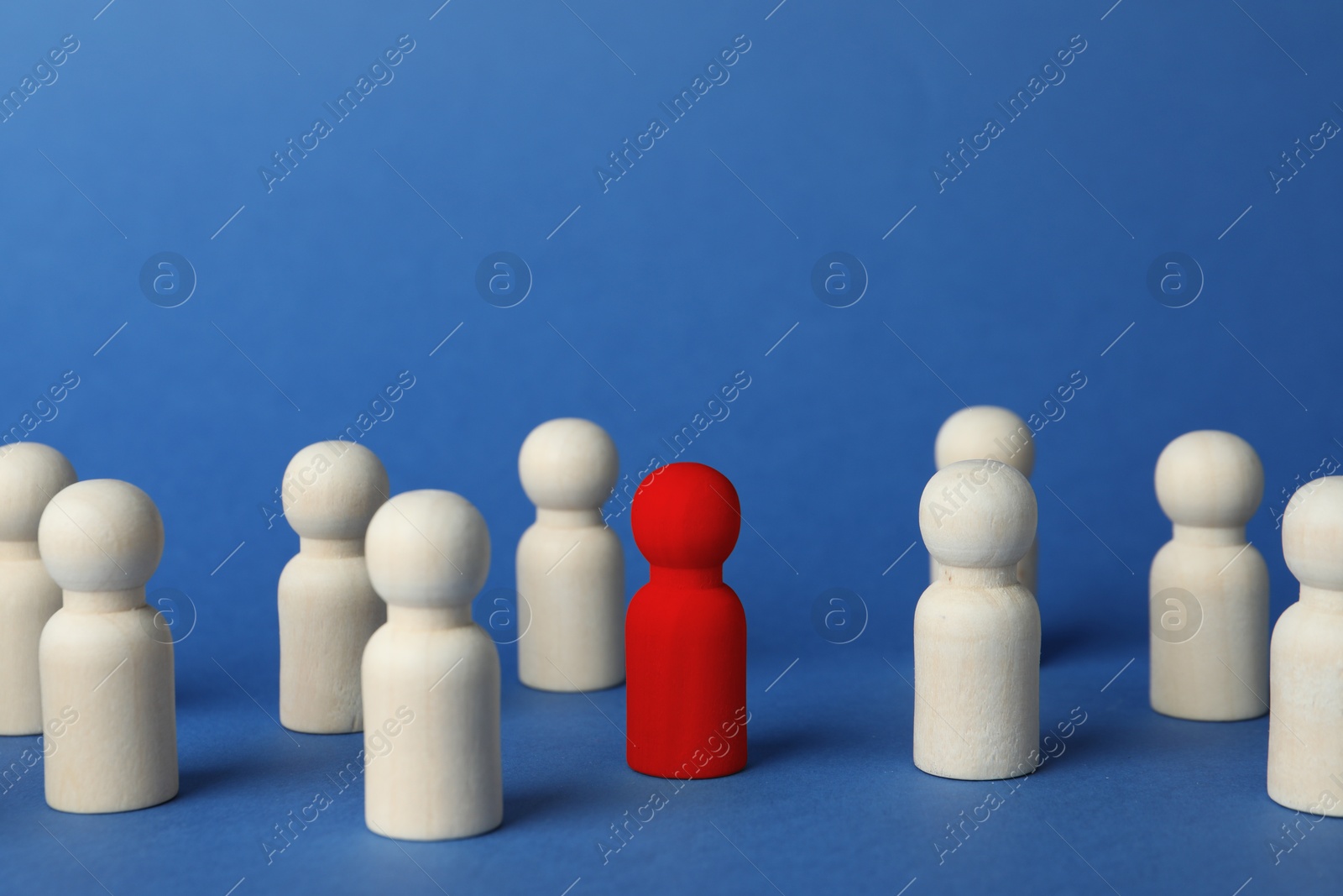 Dismissal. Red figure among wooden ones on blue background Image of Dismissal. Red figure among wooden ones on blue background