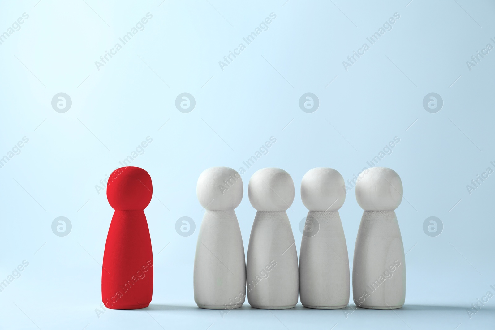 Dismissal. Red figure standing apart among wooden ones on light background Image of Dismissal. Red figure standing apart among wooden ones on light background