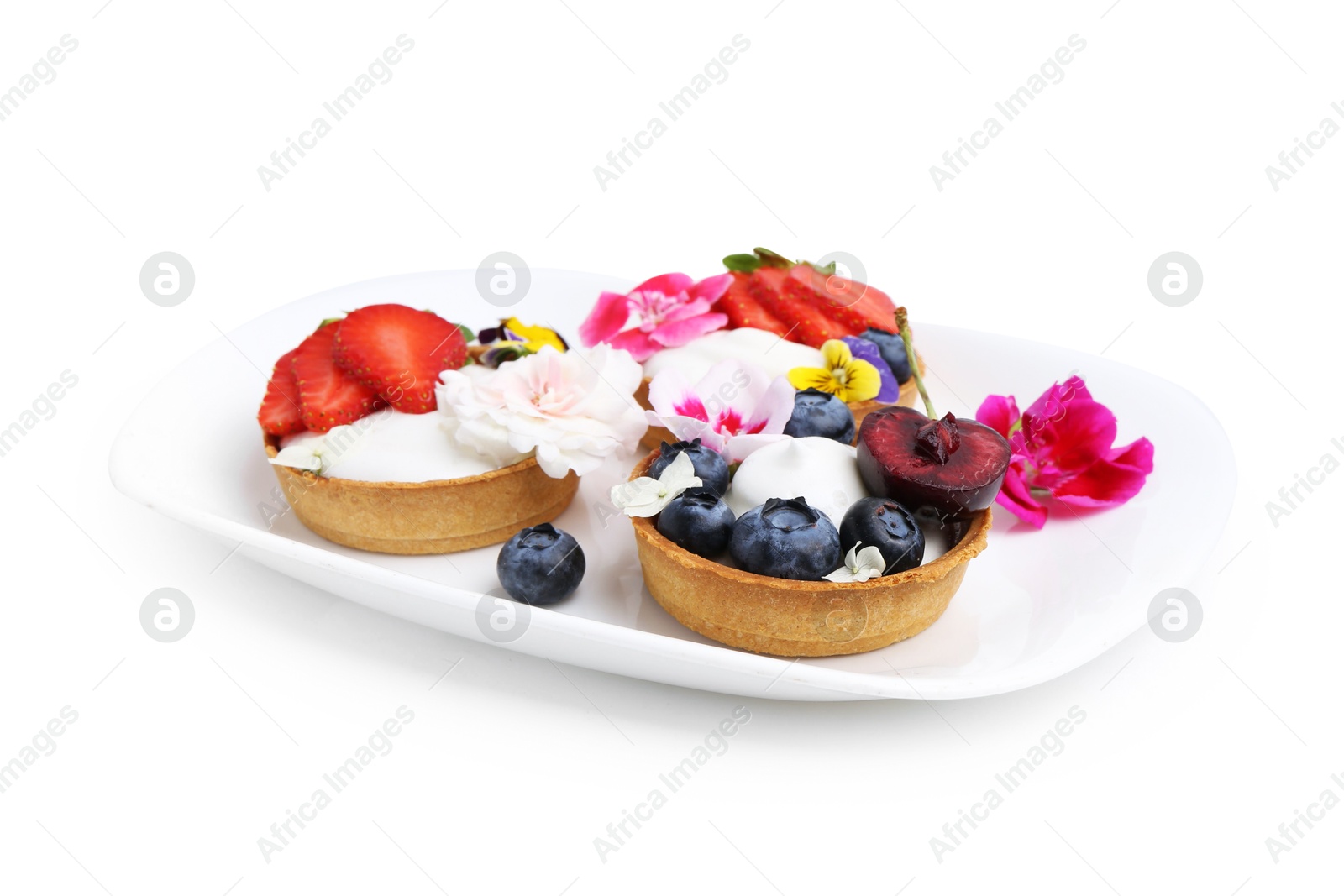Sweet tartlets with berries and flowers isolated on white. Delicious dessert Photo of Sweet tartlets with berries and flowers isolated on white. Delicious dessert