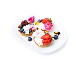 Photo of Sweet tartlets with berries and flowers isolated on white. Delicious dessert
