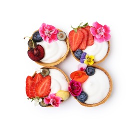 Photo of Sweet tartlets with berries and flowers isolated on white, top view. Delicious dessert