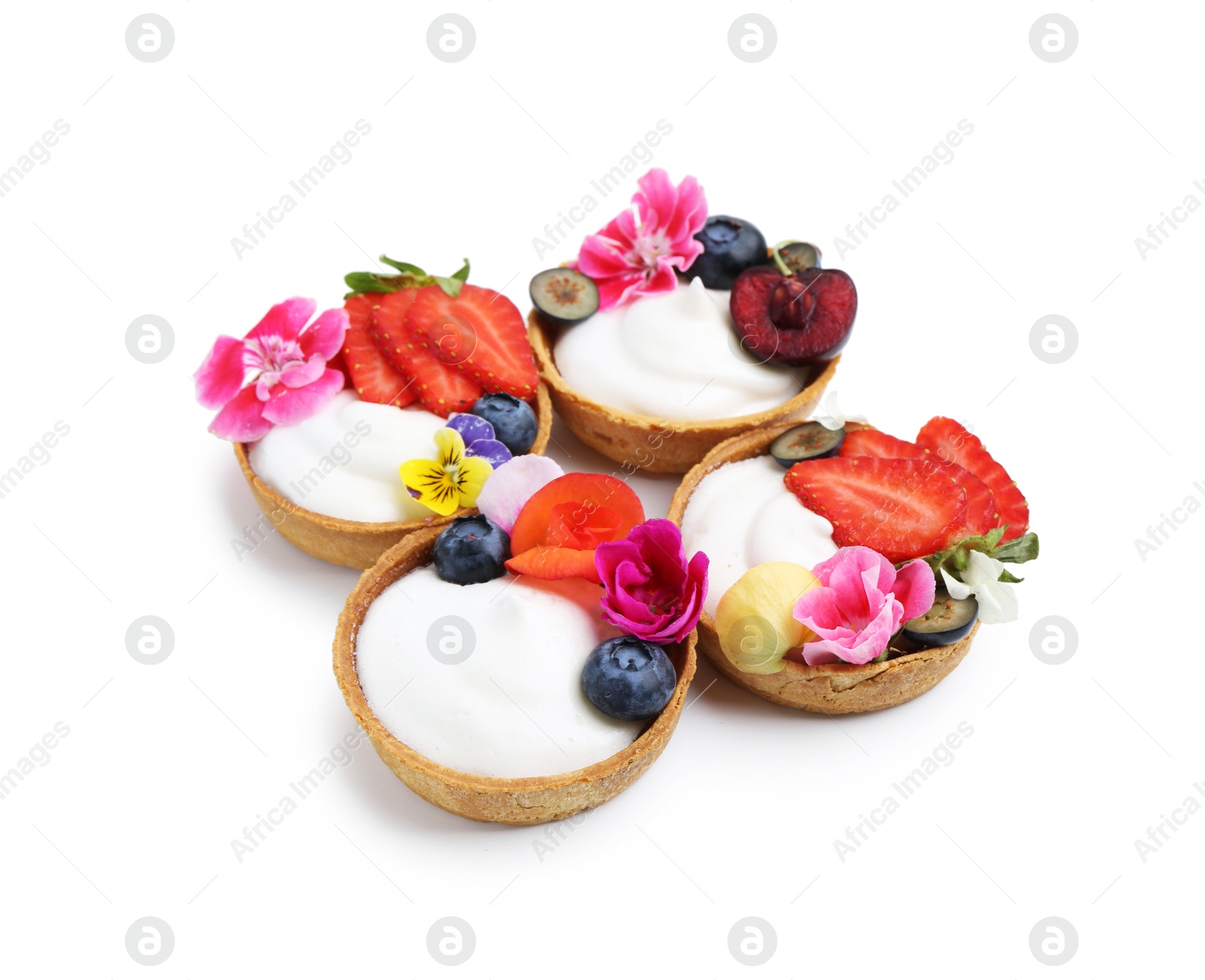 Photo of Sweet tartlets with berries and flowers isolated on white. Delicious dessert
