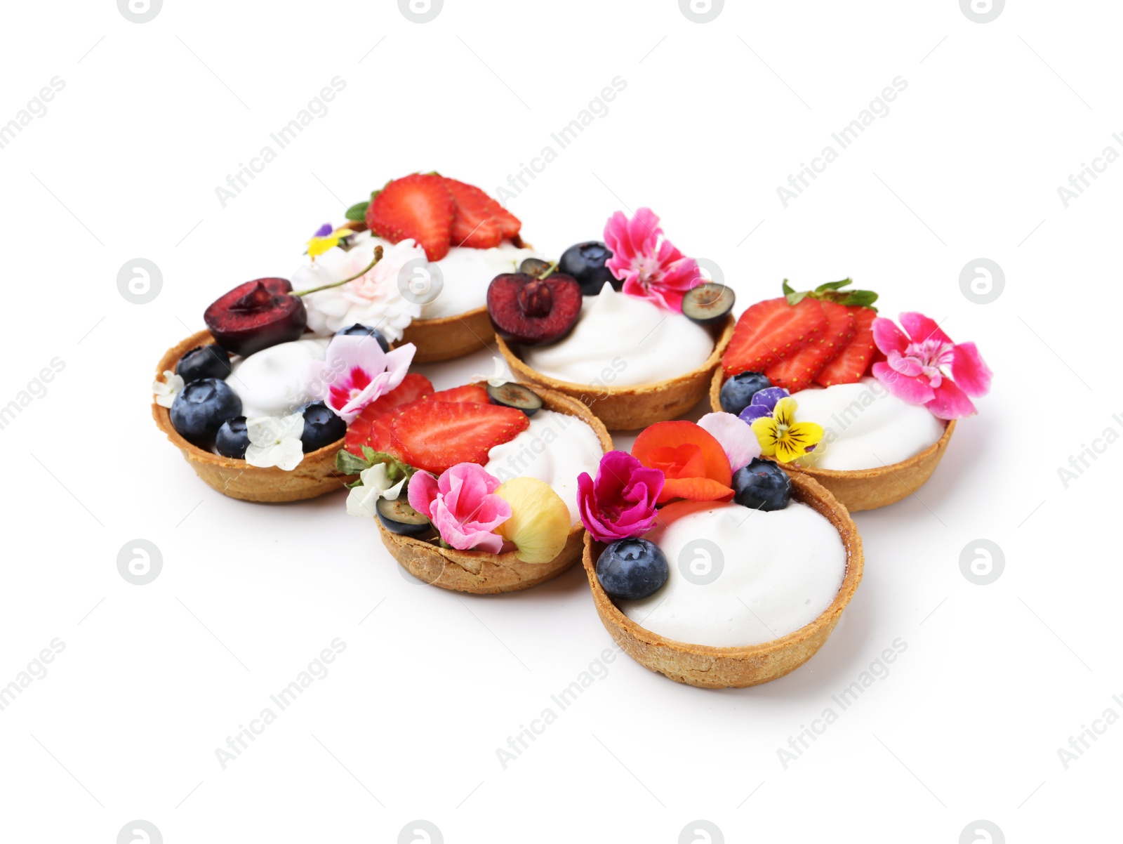Sweet tartlets with berries and flowers isolated on white. Delicious dessert Photo of Sweet tartlets with berries and flowers isolated on white. Delicious dessert