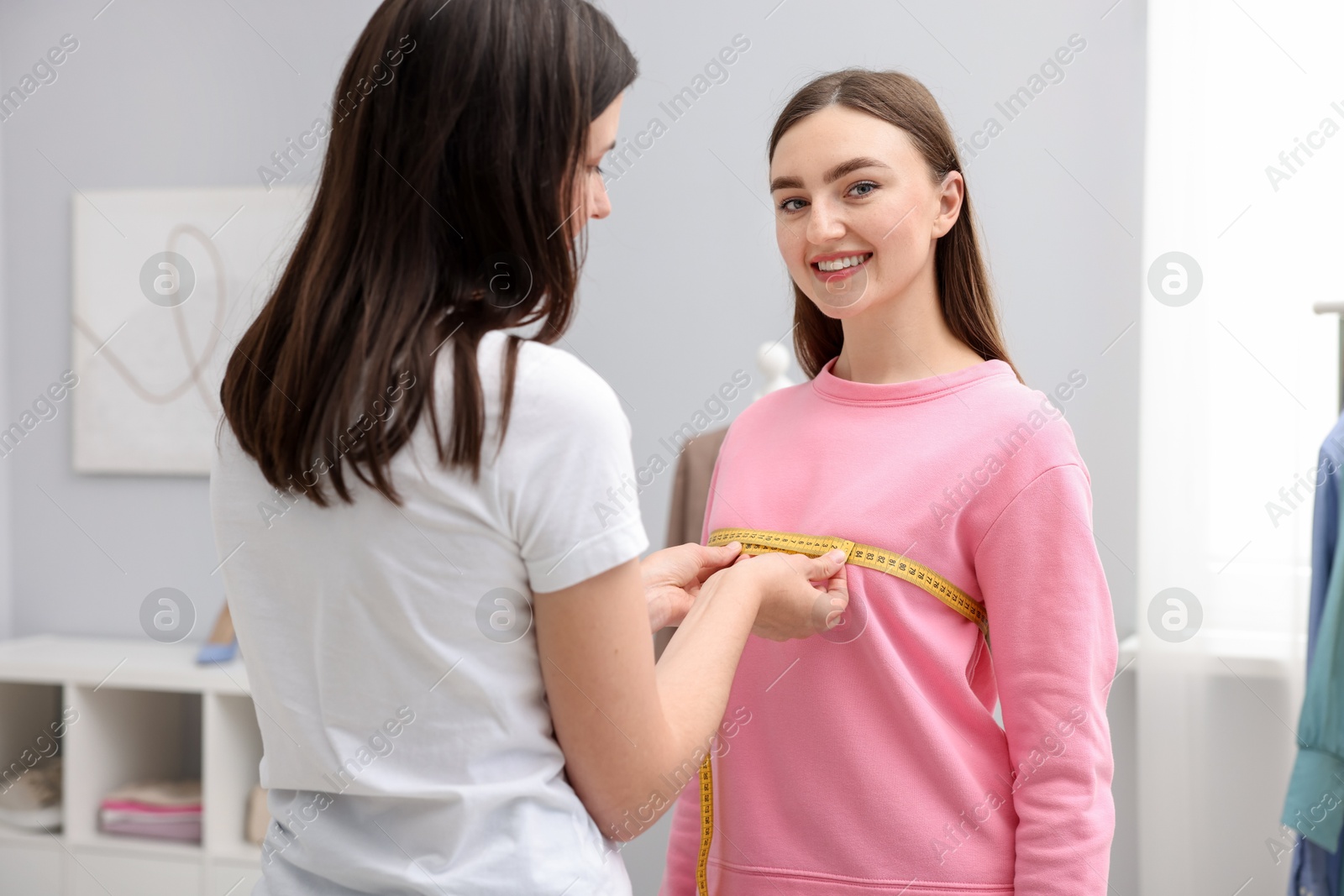 Tailor measuring woman's chest with tape in atelier Photo of Tailor measuring woman's chest with tape in atelier