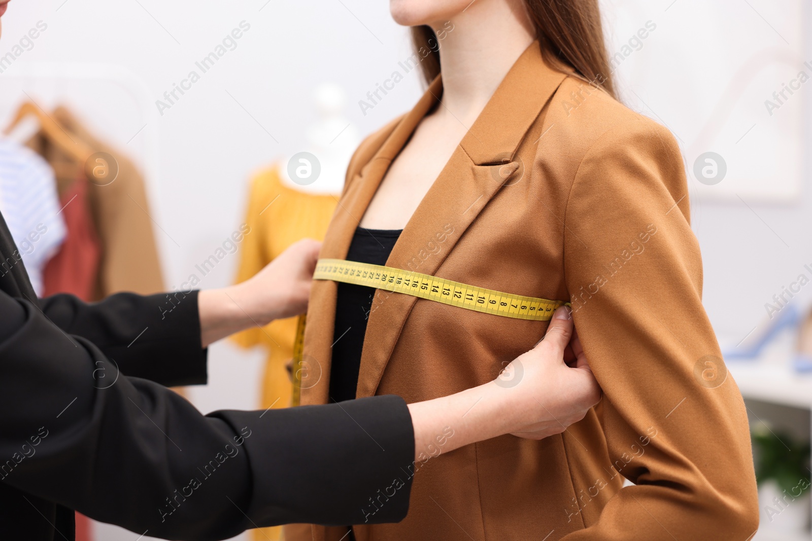 Tailor measuring jacket on woman in atelier, closeup Photo of Tailor measuring jacket on woman in atelier, closeup