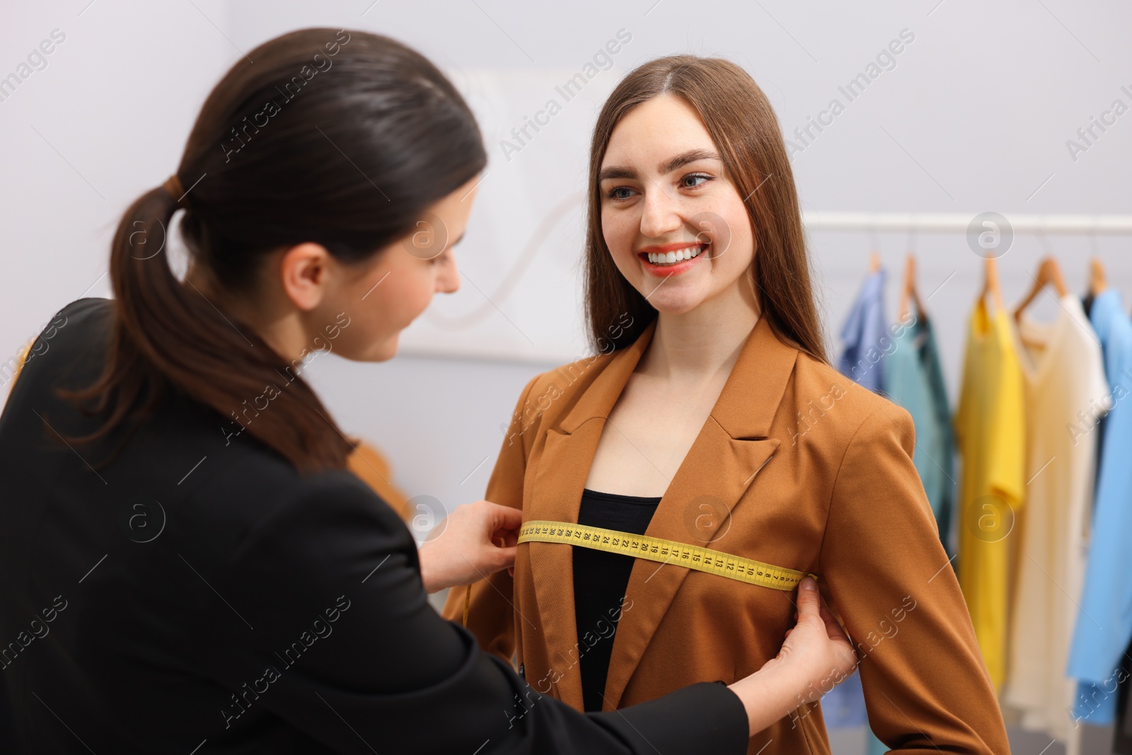 Tailor measuring jacket on woman in atelier Photo of Tailor measuring jacket on woman in atelier