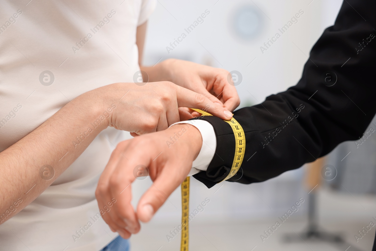 Tailor measuring jacket on man in atelier, closeup Photo of Tailor measuring jacket on man in atelier, closeup