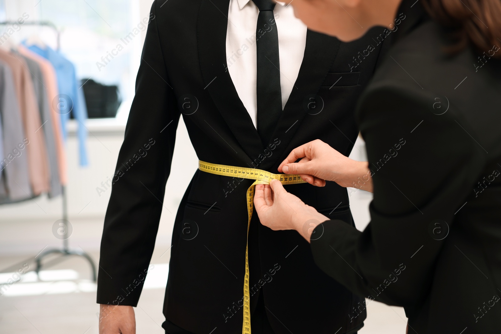 Tailor measuring jacket on man in atelier, closeup Photo of Tailor measuring jacket on man in atelier, closeup