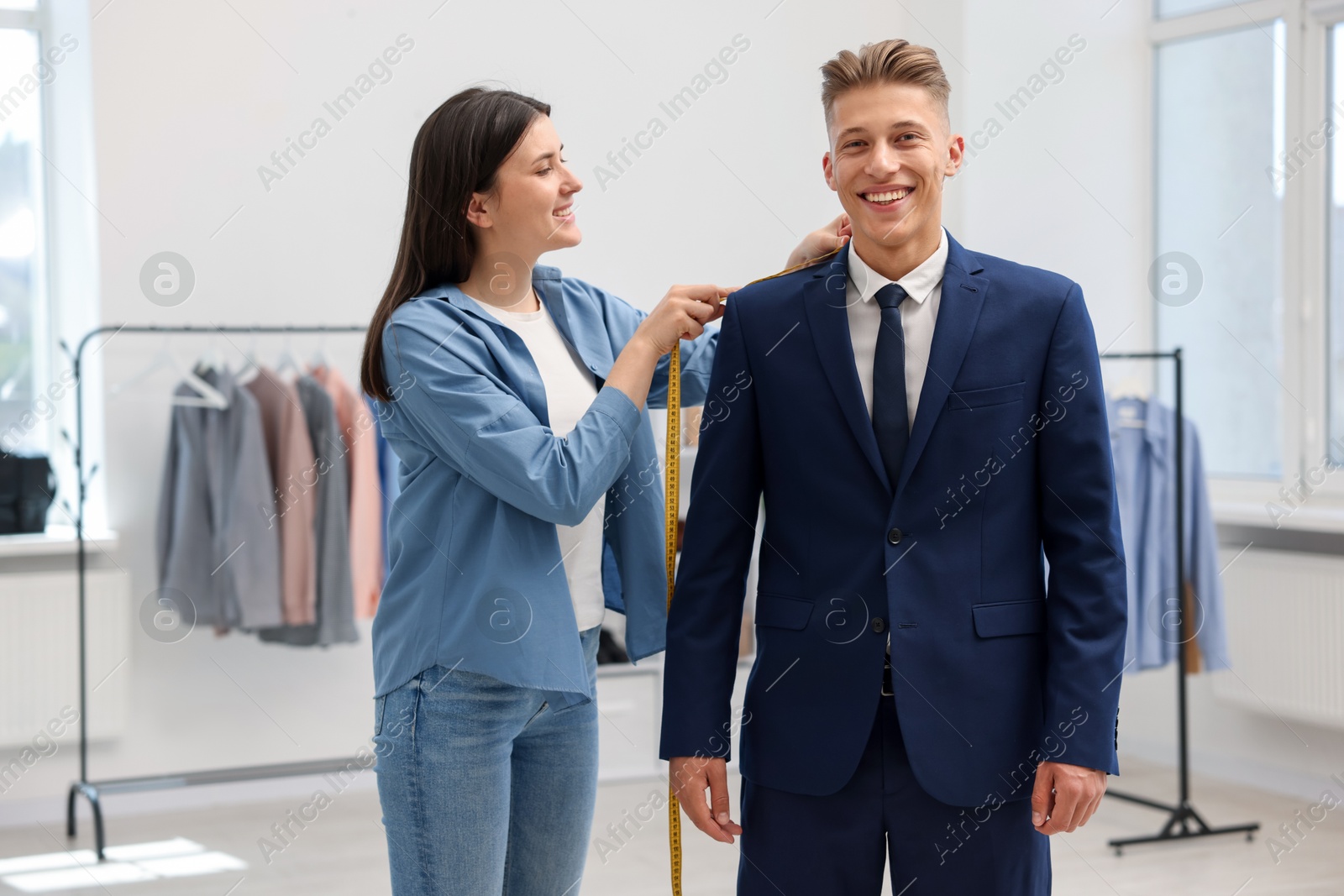 Tailor measuring jacket on man in atelier Photo of Tailor measuring jacket on man in atelier