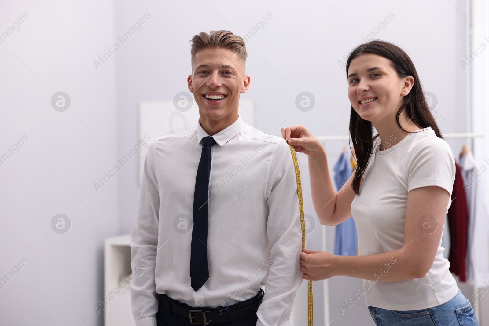 Tailor measuring woman's arm with tape in atelier Photo of Tailor measuring woman's arm with tape in atelier