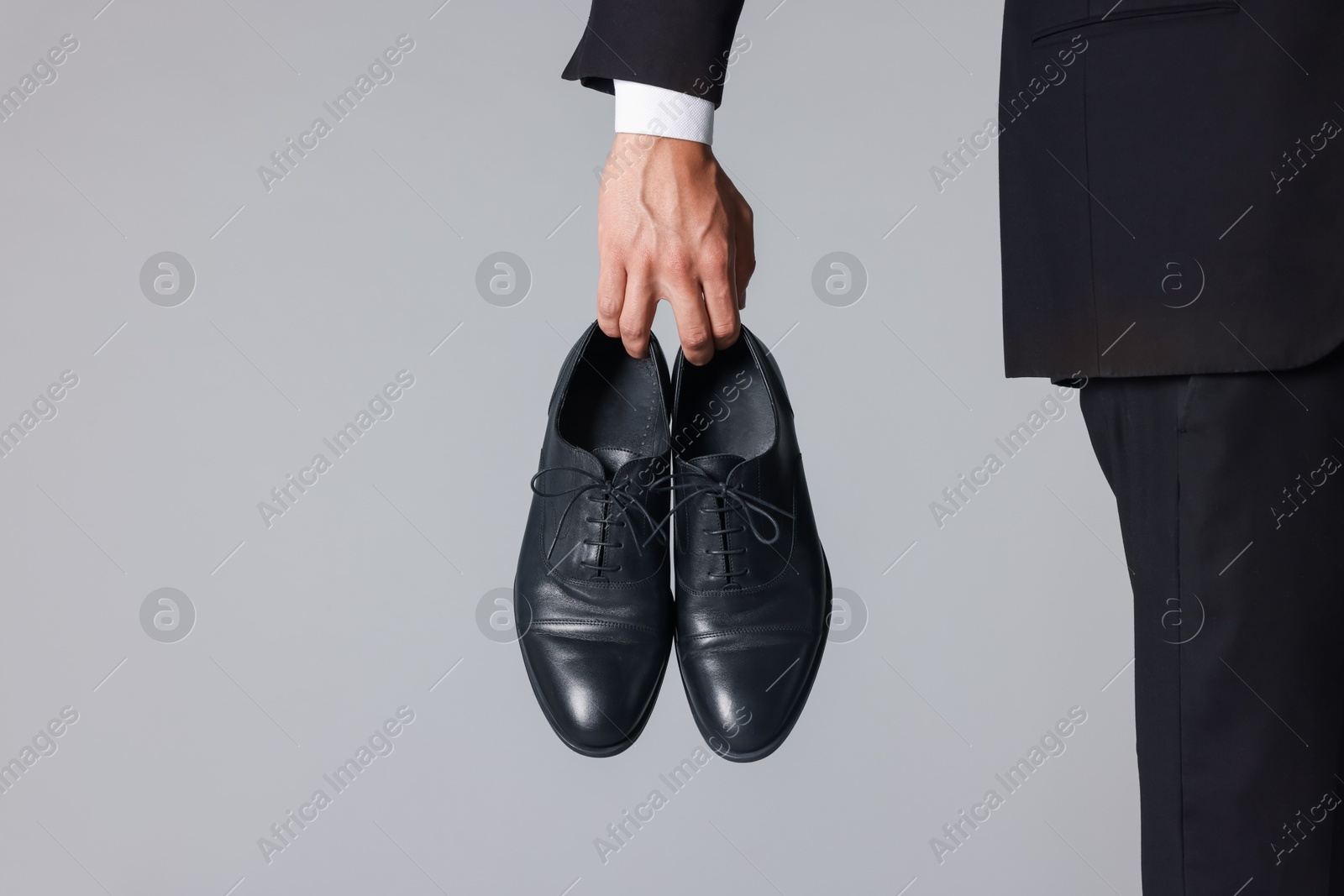Photo of Man wearing pair of black leather shoes on light background, closeup. Space for text