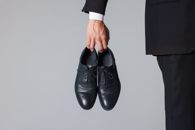 Photo of Man wearing pair of black leather shoes on light background, closeup. Space for text