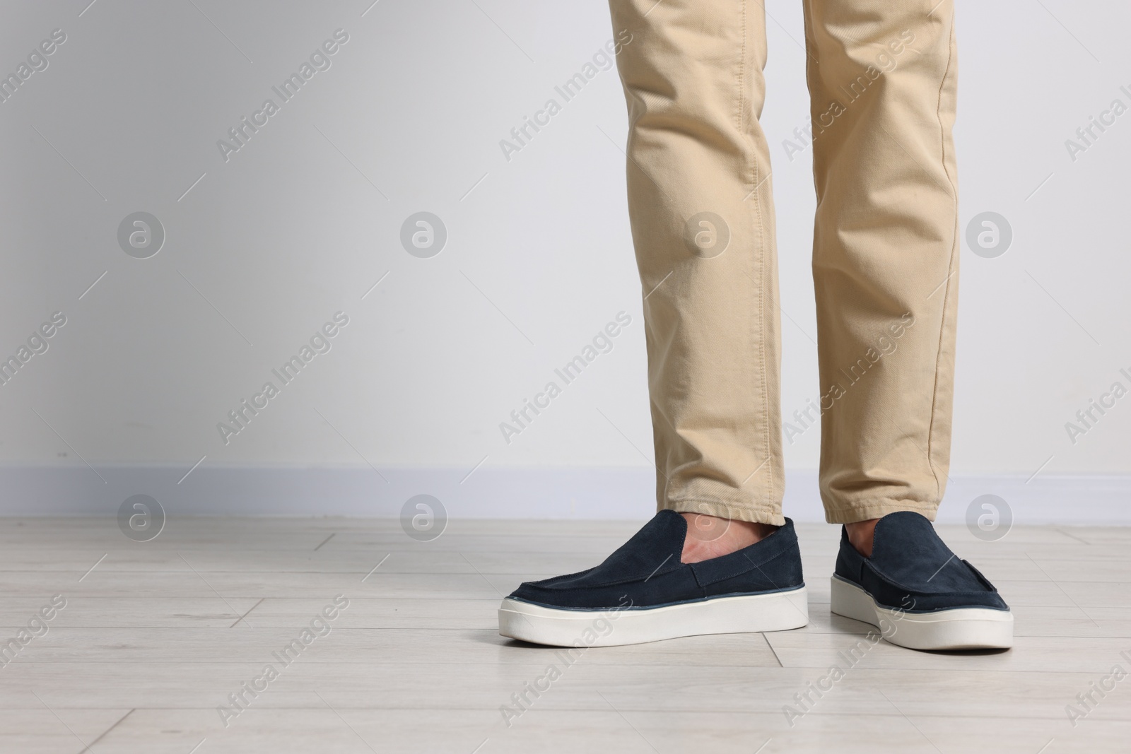Photo of Man wearing pair of dark blue shoes indoors, closeup. Space for text