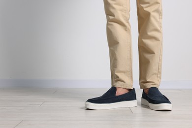 Photo of Man wearing pair of dark blue shoes indoors, closeup. Space for text
