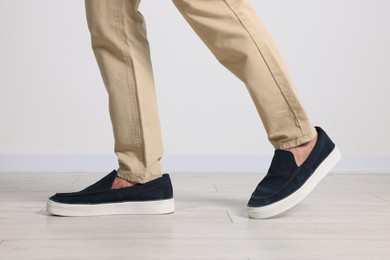 Photo of Man wearing pair of dark blue shoes indoors, closeup