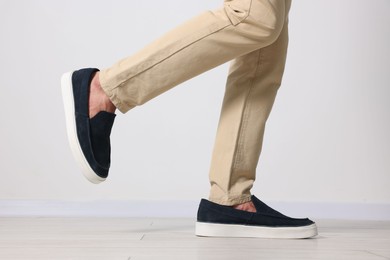 Photo of Man wearing pair of dark blue shoes indoors, closeup