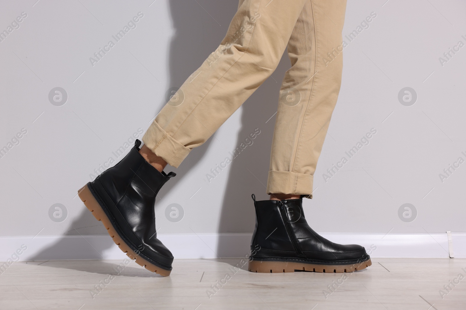 Man wearing pair of boots indoors, closeup Photo of Man wearing pair of boots indoors, closeup