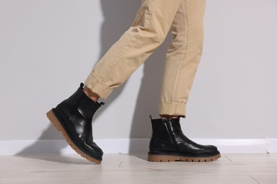 Photo of Man wearing pair of boots indoors, closeup