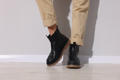 Photo of Man wearing pair of boots indoors, closeup