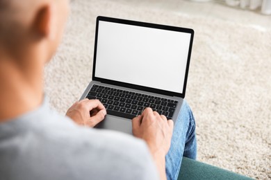 Photo of Man using laptop on sofa indoors, closeup